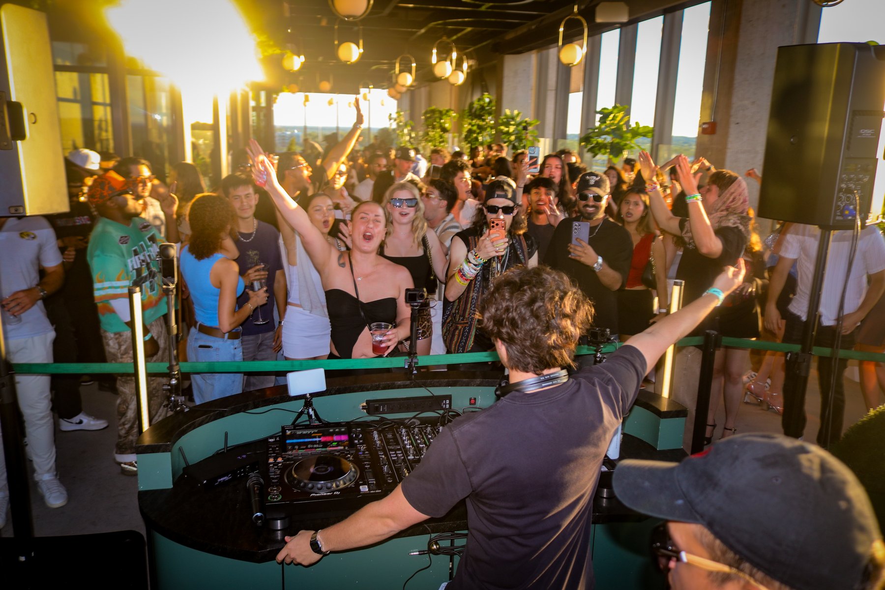 J TISTA performing with a crowd gathered around the DJ booth